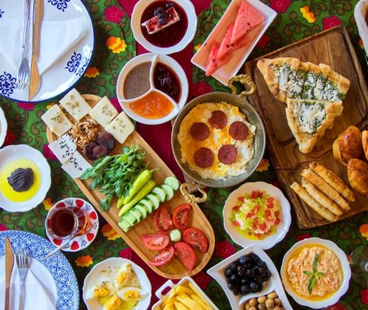 Güne dengeli ve besleyici bir öğünle başlamak, gün boyunca ihtiyaç duyulan enerjinin karşılanmasına yardımcı olabilir. Özellikle farklı besin gruplarının bir arada tüketildiği kahvaltılar, günlük beslenme düzeninin daha çeşitli hale gelmesini sağlayabilir. Son dönemde sağlıklı yaşam alışkanlıklarının daha fazla önem kazanmasıyla birlikte Vitamin Dostu Kahvaltı Önerileri de sofralarda daha fazla ilgi görmeye başladı. Taze sebzeler, meyveler, yumurta, süt ürünleri, tam tahıllar ve kuruyemişler kahvaltıların besleyici yönünü güçlendiren seçenekler arasında bulunuyor. Konulu bir haber görseli.